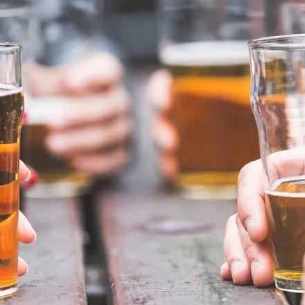 Un groupe d'adolescents est réunit autour d'une table en consommant de la bière.